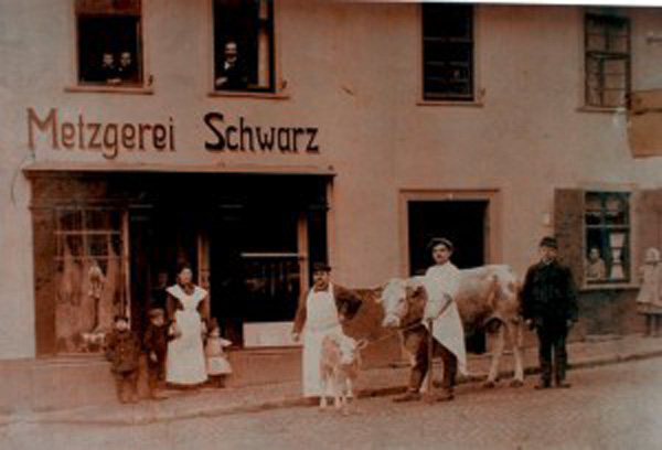 Die Familie Schwarz vor der Metzgerei in der Weilburger Niedergasse. Albert Schwarz steht hinter dem Kalb in der Bildmitte, seine Frau Sarah mit zwei Kindern in der Tür. Foto: Warlies